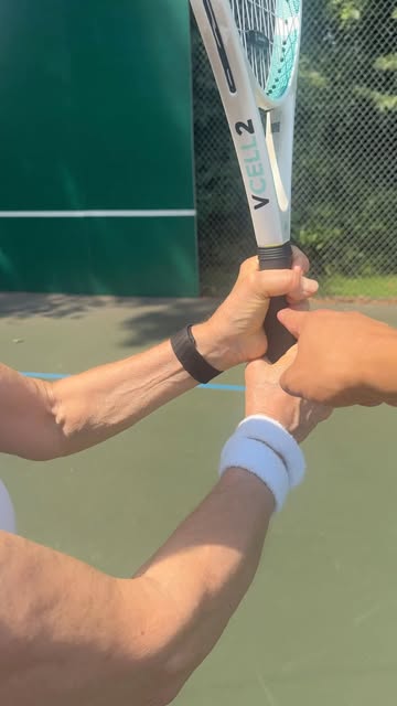 Ivan correcting a student's backhand grip